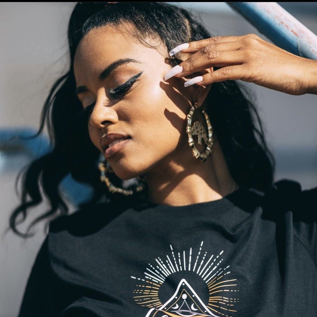 Oakland bamboo hoops on woman posing. Oakland jewelry. 18k gold plated hoop earrings.